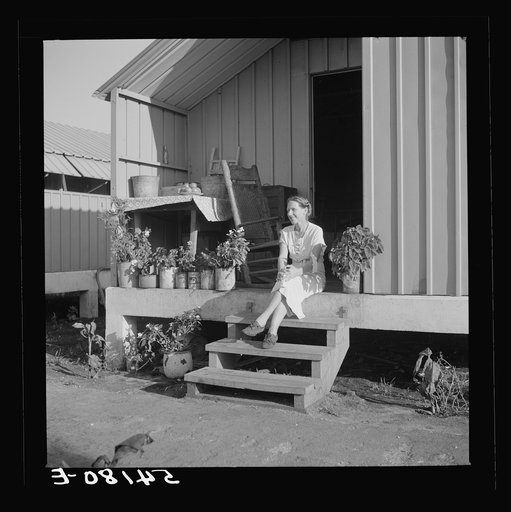 Untitled photo, possibly related to: Camp member on porch of her shelter at Osceola migratory labor camp. Belle Glade, Florida