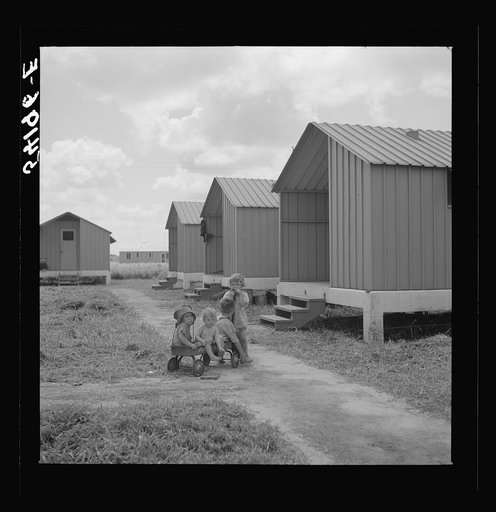 Untitled photo, possibly related to: Camp members' children playing outside their shelters at Osceola migratory labor camp. A nursery school and equipped playground is to be provided for them. Belle Glade, Florida