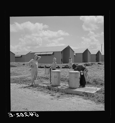 Untitled photo, possibly related to: Running water and garbage and refuse disposal cans are placed at head of each shelter unit division in Osceola migratory labor camp. Belle Glade, Florida