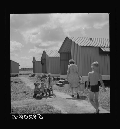 Carrying water which is easily available at head of each shelter unit at Osceola migratory labor camp. Belle Glade, Florida