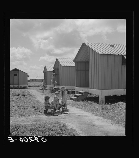 Untitled photo, possibly related to: Camp members' children playing outside their shelters at Osceola migratory labor camp. A nursery school and equipped playground is to be provided for them. Belle Glade, Florida