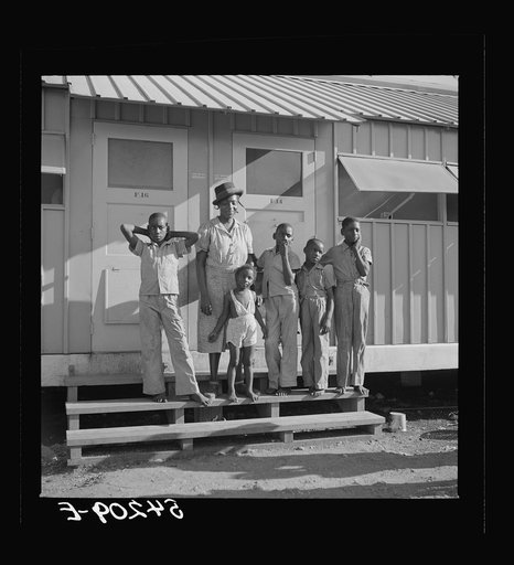 Untitled photo, possibly related to: The Robinson family outside their shelter at Okeechobee migratory labor camp. Belle Glade, Florida
