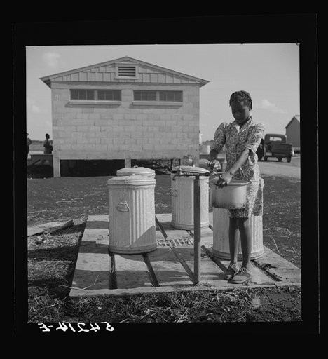 Running water and garbage and refuse disposal are placed at head of each shelter unit division of Okeechobee migratory labor camp. Belle Glade, Florida