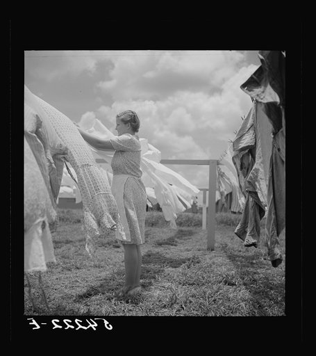 Untitled photo, possibly related to: Camp member hanging out clothes outside of utility building which is equipped with complete laundry facilities and showers. Osceola migratory camp, Belle Glade, Florida