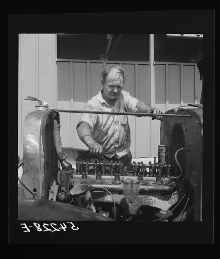 Camp member repairing his car outside his shelter. Osceola migratory labor camp. Belle Glade, Florida