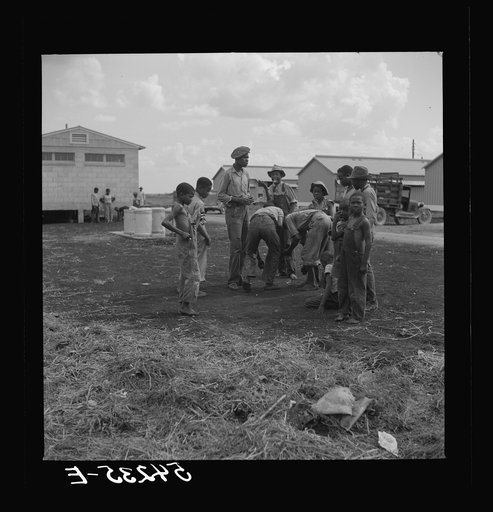 Untitled photo, possibly related to: Camp members' children playing marbles outside their shelter units at Okeechobee migratory labor camp. Belle Glade, Florida