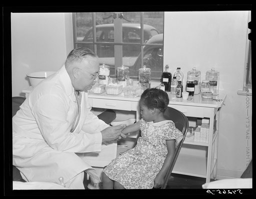 Dr. William J. Buck gives typhoid innoculation to child in clinic at Okeechobee migratory labor camp. Belle Glade, Florida