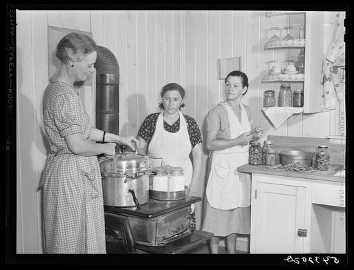 Mrs. Ruth Lina, home management supervisor, helping some of the project women can milk. Terrebonne Project, Schriever, Louisiana