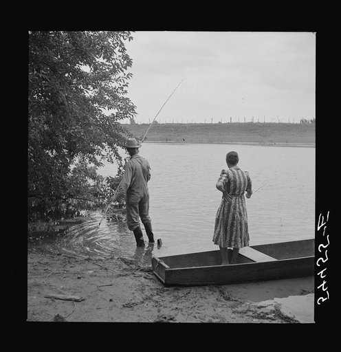 Farmer and his wife fishing in Cane River on Fourth of July. Later the whole family had a fish fry. Near Natchitoches, Louisiana