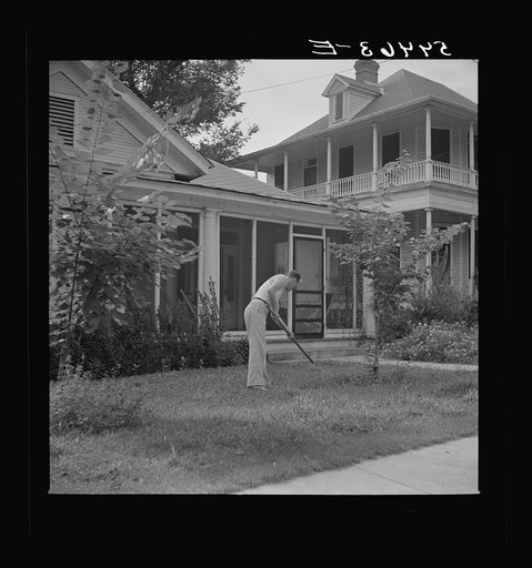 Man in front of his home weeding his lawn on Sunday. Natchitoches, Louisiana