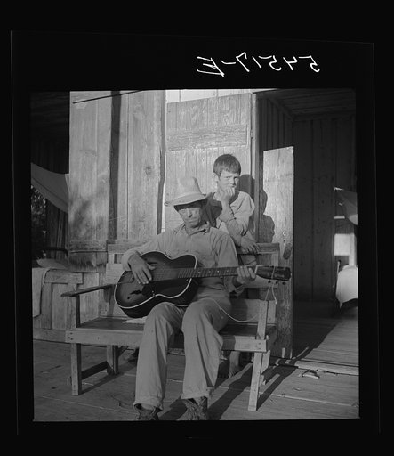Untitled photo, possibly related to: Farmer playing guitar on the porch in the evening. Near Natchitoches, Louisiana