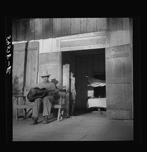 Untitled photo, possibly related to: Farmer playing guitar on the porch in the evening. Near Natchitoches, Louisiana