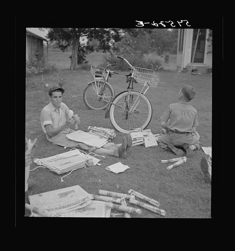 Boys in Natchitoches, Louisiana, folding papers before delivering them in the afternoon