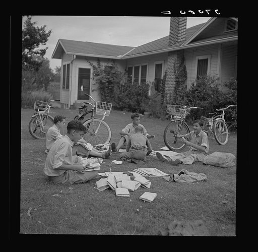 Boys in Natchitoches, Louisiana, folding papers before delivering them in the afternoon