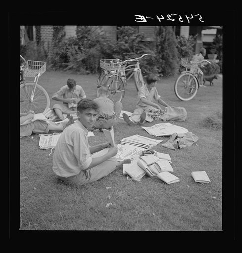 Untitled photo, possibly related to: Boys in Natchitoches, Louisiana, folding papers before delivering them in the afternoon