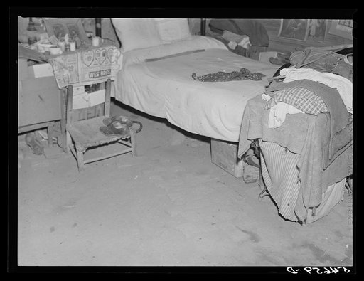 Untitled photo, possibly related to: Melrose, Natchitoches Parish, Louisiana. Bedroom with religious pictures, etc. on mud walls of old hut built and still occupied by French mulattoes, near John Henry cotton plantation. Belongs to Rocque family (see general caption)