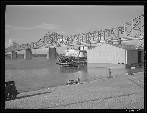 Untitled photo, possibly related to: Riverboat carrying cargo leaving dock along waterfront on Ohio River. Louisville, Kentucky