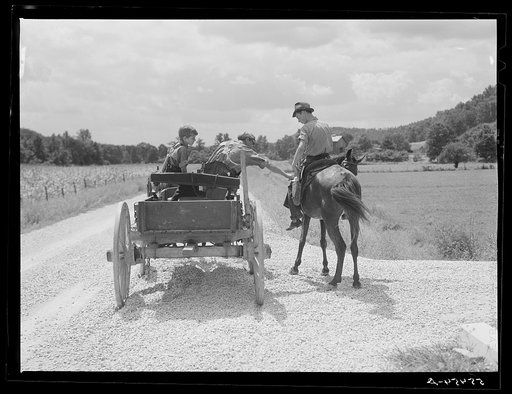 Rural mailman who has brought the mail to the crossroads transfers letters and packages to another postman's saddlebags. This rider takes the mail further up the side road and creek beds where no wagon or car can go. In the mountain section near Morehead, Kentucky