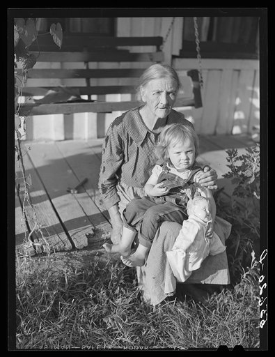 Mountain woman and grandchild sitting on the porch of their home up Frozen Creek, Breathitt County, Kentucky