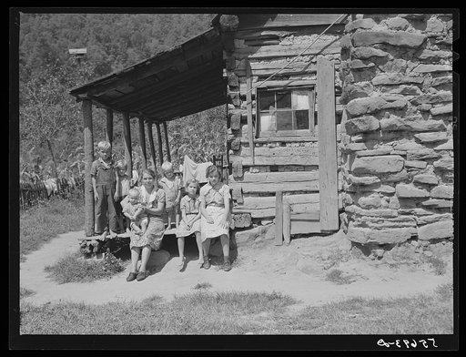 Mountain family on porch of their home made of hand hewn logs up South Fork of Kentucky River, Breathitt County, Kentucky