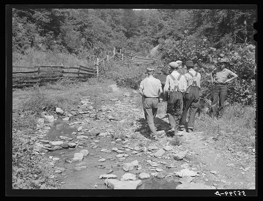 Mountain people carrying a homemade coffin up the creek bed to the family plot on the hillside where it will be buried. This section is too isolated to hold any formal funeral services immeditately. Up South Fork of the Kentucky River near Jackson, Kentucky