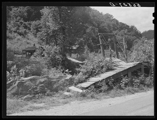 Swinging bridge crossing over creek from main road to post office and store. Ary, Kentucky