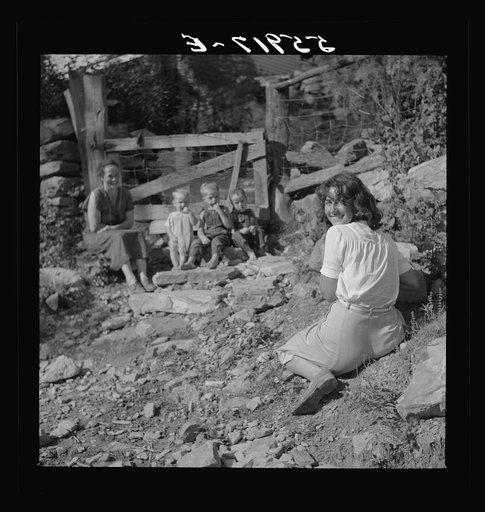 Marion Post photographing mountain children on stone steps of their home. Up Stinking Creek, Pine Mountain, Kentucky