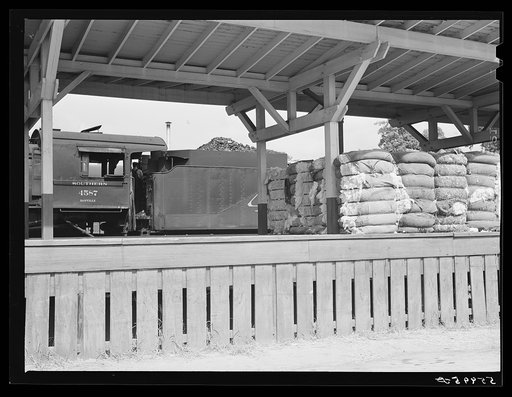 Railway station with bales of cotton on platform. Mebane, North Carolina