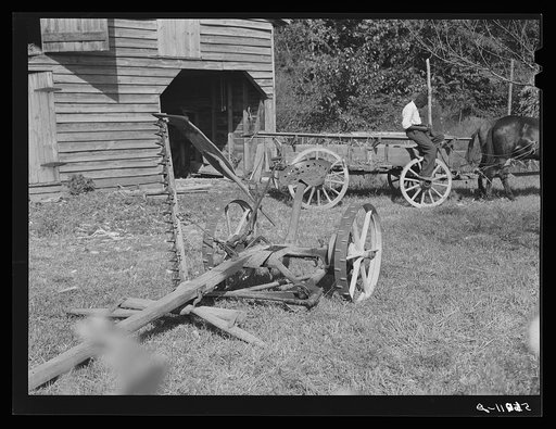 Untitled photo, possibly related to: Negro helper with wagon in front of J.V. Harris' barn, nine miles south of Chapel Hill on Highway 15. Chatham County, North Carolina