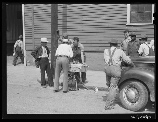 Peddler selling patent medicines to farmers outside warehouse on opening day of tobacco market in Mebane, North Carolina where many Caswell County farmers sell their tobacco at auction