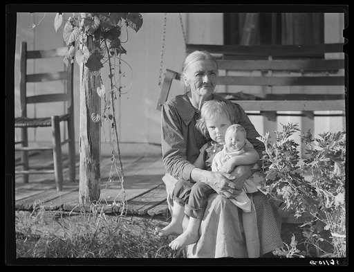 Mountain woman and grandchild sitting on the porch of their home up Frozen Creek, Breathitt County, Kentucky
