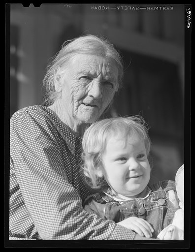 Mountain woman and grandchild sitting on the porch of their home up Frozen Creek, Breathitt County, Kentucky