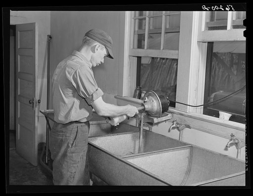 Untitled photo, possibly related to: E. O. Foster's son (tenant purchase family) washing milk bottles in their Caswell dairy. Caswell County, North Carolina