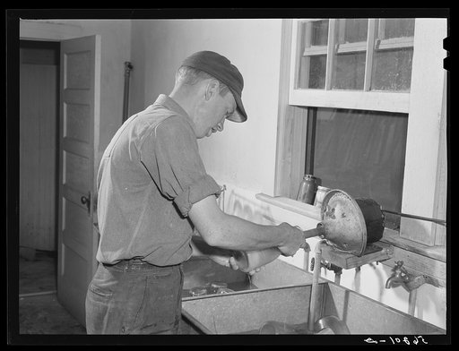 E. O. Foster's son (tenant purchase family) washing milk bottles in their Caswell dairy. Caswell County, North Carolina
