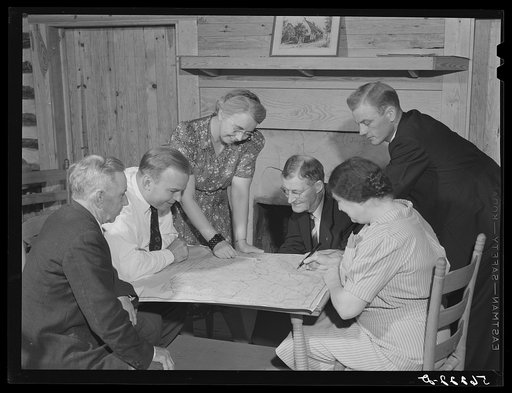 Meeting of the neighborhood or community land use planning committee in Locust Hill. Studying and working on the map of Caswell County are Walter H. Williamson, also chairman of FSA (Farm Security Administration) tenant purchase committee; J.E. Zimmerman, county agent; Mande Searcy, home demonstrati