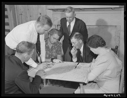 Meeting of the neighborhood or community land use planning committee in Locust Hill. Studying and working on the map of Caswell County are Walter H. Williamson, also chairman of FSA (Farm Security Administration) tenant purchase committee; J.E. Zimmerman, county agent; Mande Searcy, home demonstrati