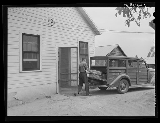 E.O. Foster's son taking the empty milk bottles out of their delivery wagon to be washed and refilled in the pasteurizing plant of their Caswell dairy. They are FSA (Farm Security Administration) tenant purchase borrowers. Caswell County, North Carolina