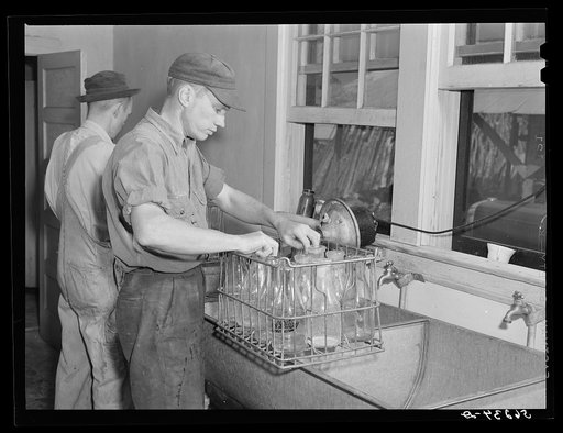 E.O. Foster's son (tenant purchase family) washing milk bottles in their Caswell Dairy. Caswell County, North Carolina