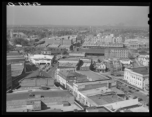Untitled photo, possibly related to: Five points, center of city, with Chesterfield cigarette factories in background. Durham, North Carolina