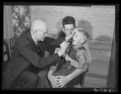 Dr. S.A. Malloy examining Mr. William H. Willis's son Bobby in their home.  Mr. Willis is a FSA (Farm Security Administration) borrower. Blanch, Caswell County, North Carolina