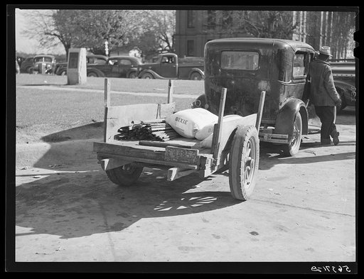Farmer returning home after selling his tobacco at auction. In the trailer are sacks of flour and meal and the tobacco sticks. Yanceyville, Caswell County, North Carolina