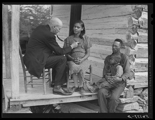 Dr. S.A. Malloy examining Louis Graves and his family on their front porch. They are FSA (Farm Security Administration) borrowers. Caswell County, North Carolina