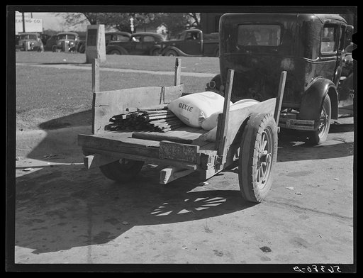 Farmer returning home after selling his tobacco at auction. In the trailer are sacks of flour and meal and the tobacco sticks. Yanceyville, Caswell County, North Carolina