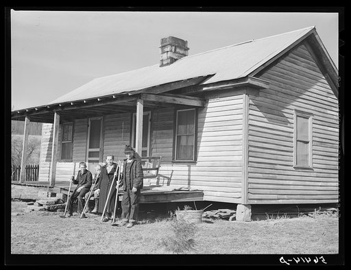 Dutton ("Dut") Calleb and his family with their homemade hoes on the porch of their home. Southern Appalachian Project near Barbourville, Knox County, Kentucky