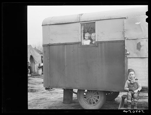 Untitled photo, possibly related to: Children looking out of trailer window. Trailer where C.E. Children and family live in highway about three miles from Fort Benning. He is an auto mechanic and came up to Columbus, Georgia two weeks ago from Albany, Georgia and now works at Columbus Motor Company.