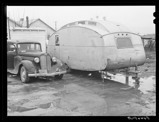 Trailer and car belonging to Paul Knight, construction worker at Fort Benning building new barracks. He pays two dollars for trailer space (only) in W.T. Willis' backyard, is from Stone Mountain, Atlanta, Georgia. He said the bad roads were one of the worst problems around there and agreed that thin