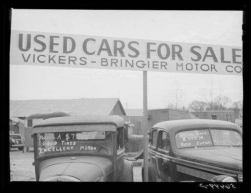 Service station, used cars for sale. Trailers are parked very congested in section near road show and carnival. Alexandria, Louisiana