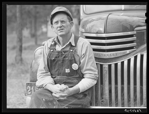 Construction worker from Monroe, Louisiana. Sitting on car in front of his shack before leaving for evening shift. Camp Livingston, Alexandria, Louisiana