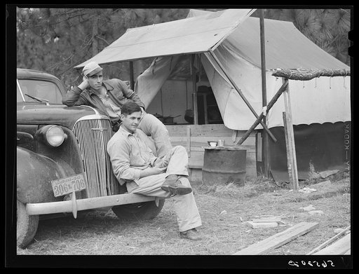 Untitled photo, possibly related to: Construction workers from Monroe, Louisiana. Sitting on car in front of their shacks before leaving for evening shift. Camp Livingston, Alexandria, Louisiana
