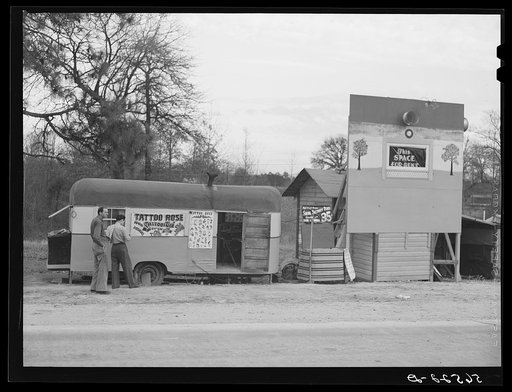 Untitled photo, possibly related to: Signs and trailer with tattoo artist on highway near Fort Beauregard. Alexandria, Louisiana